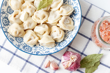Close-up of Dumplings in a blue plate on a checkered towel. Ravioli with meat. Traditional Cuisine