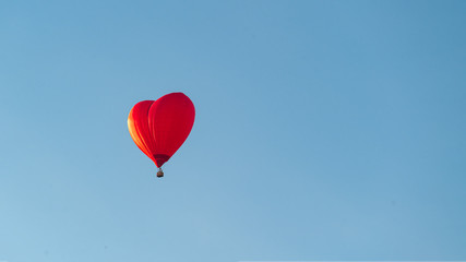 Fototapeta na wymiar red balloon heart in blue sky concept of love