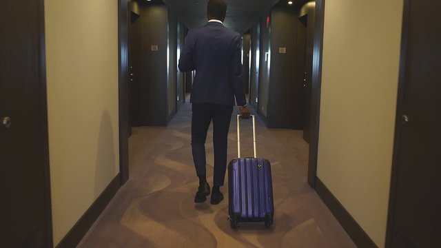 Man holding suitcases, black doorman or bellboy help clients of hotel to carry baggage