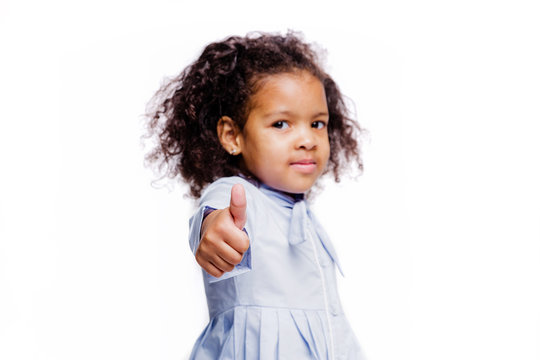 Portrait of pretty little african american girl in blue dress shows gesture, everything is fine, a class sign on white background