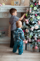 little boys decorating christmas tree