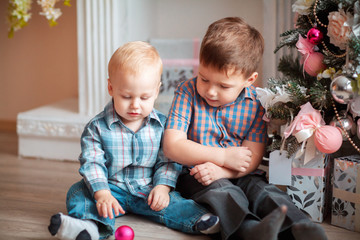 little boys playing with christmas tree toys
