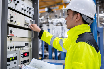 Electrical engineer woman checking voltage at the Power Distribution Cabinet in the control room,preventive maintenance Yearly,Thailand Electrician working at company