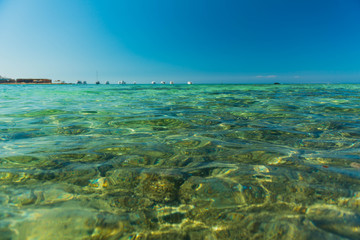transparent wavy red sea water surface with horizon on background