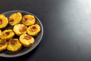 Baked potatoes with lard, a strata-fast delicious lunch, in a plate on a stone table. Copy space.