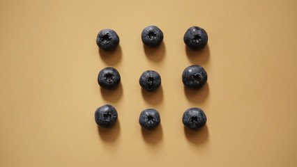 Blueberries are laid out in rows on a gold background - perfectionism concept