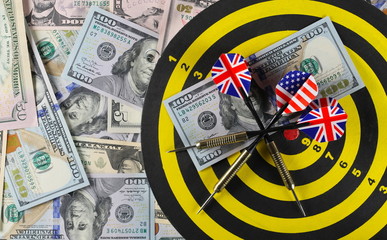 American dollars, banknotes, cash money pile with dartboard target and throwing dart background and...