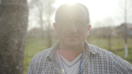 Portrait face young man with glasses look at camera in nature garden green meadow park adult agriculture garden male worker casual one person portrait