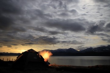 sunset over a lake with tent