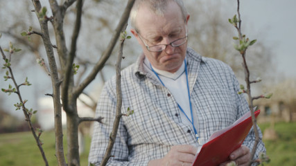 Close up face young man with glasses check tree write in nature garden green meadow park adult agriculture garden male worker casual one person portrait