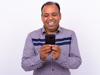 Portrait of happy mature overweight Indian businessman using phone