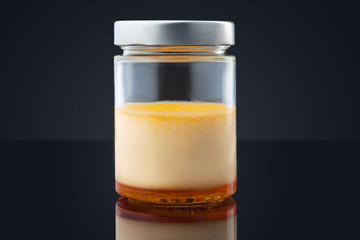 Cream caramel in a jar isolated on black background