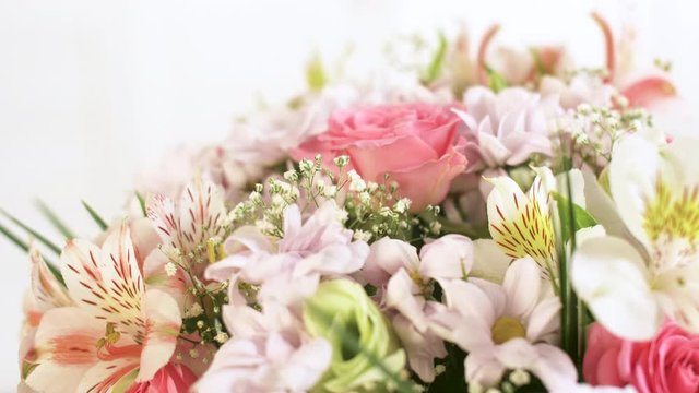 Beautiful large bouquet of different flowers rotating on a white background. Close up of differents colored summer and spring flowers. 4k background footage.