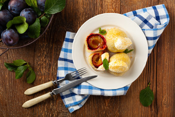 Dumplings with plums, topped with plum sauce or served with cream and sugar.
