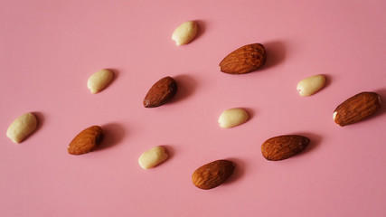 Almonds and peanuts on a pink background - bright summer picture