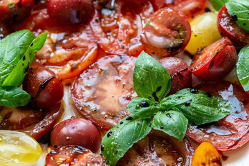 Bunte Tomaten mit Balsamicoessig, Olivenöl, Pfeffer, Basilikum und Salz