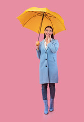 Portrait of dreamy girl holding yellow umbrella