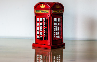 miniature london phonebox on glass with white background
