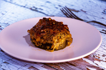  Portion of stuffed aubergines in the oven on rustic wooden table