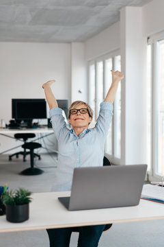 Happy successful businesswoman stretching