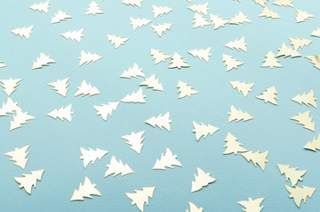 Closeup of golden shiny trees confetti on the blue surface