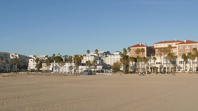 California summertime beach aesthetic, sunny blue sky, sand and many different beachfront weekend houses. Seafront buildings, real estate in Santa Monica pacific ocean resort near Los Angeles CA USA.