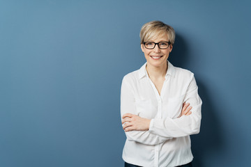 Smiling woman in white blouse with crossed arms