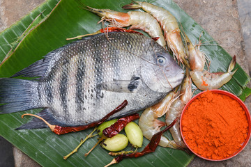 Raw fish Pearl spot and prawns, shrimp in Kerala India. Fresh seafood ingredients of very popular...