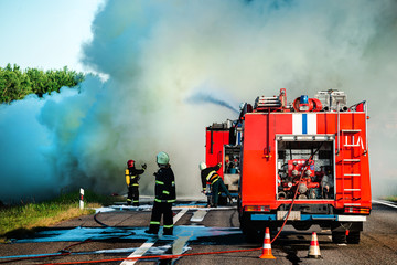 firefighter extinguishes a burning car after an accident