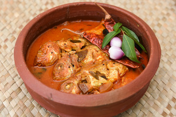 Kerala Masala fish curry in coastal area, Alappuzha south Indian and Sri Lanka, Malaysia. made by marinated mackerel fish, coconut milk, 
 Indian spices. seafood in clay or mud pot.