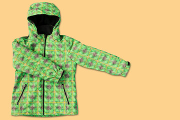 green womens winter jacket, for skiing, on yellow background, concept of seasonal discounts