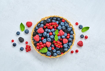 Blueberry, raspberry, blackberry, redcurrant in basket. Fresh blueberry, berries mix on marble. Red raspberry, mint creative composition. Colorful trendy concept, top view.