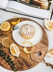 Lemon tart with merengue sweet dessert over white marble table in cafe. French cuisine, comfort...