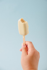 Chocolate cake in the form of ice cream on a stick on a white plate and a colored background