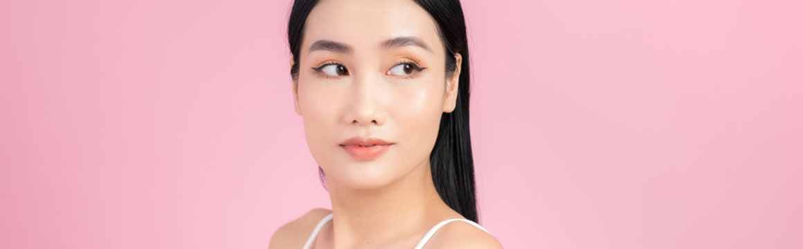Portrait of Asian healthy skin woman beautiful face close up over pink background