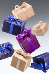  Present. Flying boxes in bright paper tied with ribbon with bow on gray background. Holidays and greeting card concept.
