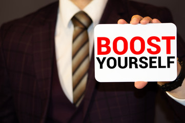 Obraz premium BOOST YOUR SELF CONFIDENCE, message on the card shown by a man, vintage tone
