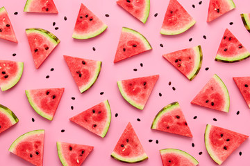 Watermelon colorful pattern on pink background. Fresh red watermelon slices closeup, wallpaper, top view. Creative summer concept, fashionable trendy flat lay