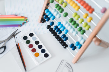 Back to school. Items for the school on a blue wooden table. School supplies on white board background. Back to school concept.