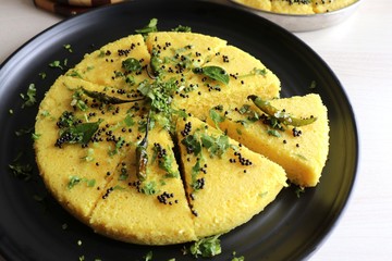 Indian traditional Dal dhokla. Khaman dhokla is a famous dish of Gujarat. Made using rice, healthy mix lentils and pulses, along with spices. garnished with coriander & fried chilies. Copy space.