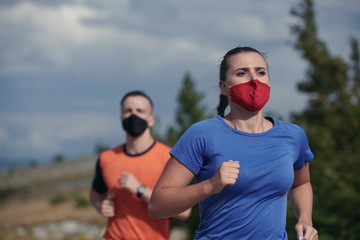 Fototapeta premium couple running in nature wearing mask