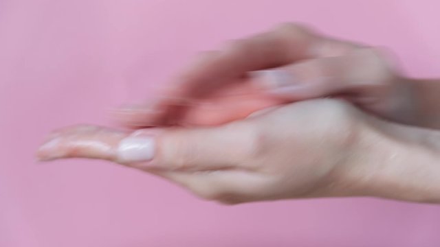 Female wash hands with pink soap over pink background. Cleansing, anti bacteria procedure