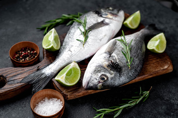 Raw dorado fish with ingredients on stone background