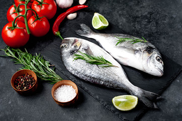 Raw dorado fish with ingredients on stone background