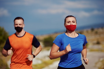 Fototapeta premium couple running in nature wearing mask