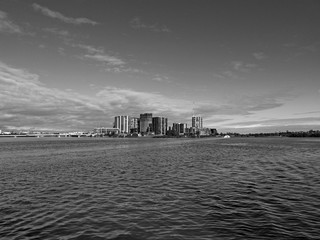 Beautiful black and white view of high-rise buildings on the riverbank on a sunny day with light clouds, Parramatta river, Meadowbank, Sydney, New South Wales, Australia
