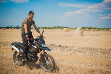 Fototapeta na wymiar Young man on a motorcycle at field, hobby of modern people, lifestyle 