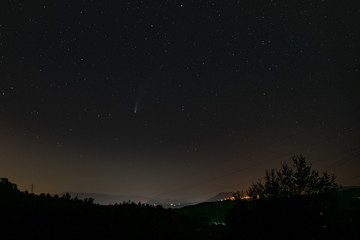 night sky with stars and neowise comet with a landscape