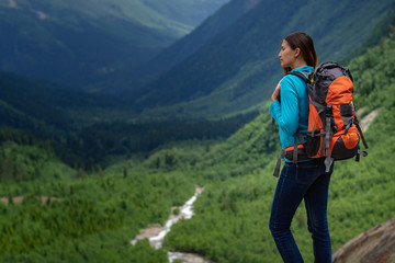 Fototapeta na wymiar Backpacker on top of a mountain enjoying valley view