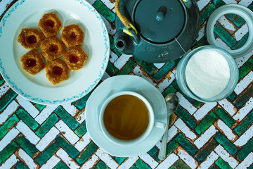 Still life con Taza de té negro con azúcar, limones y galletas en el fondo de la mesa rústica